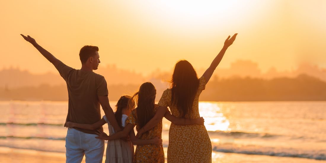 Famille à la plage au coucher de soleil